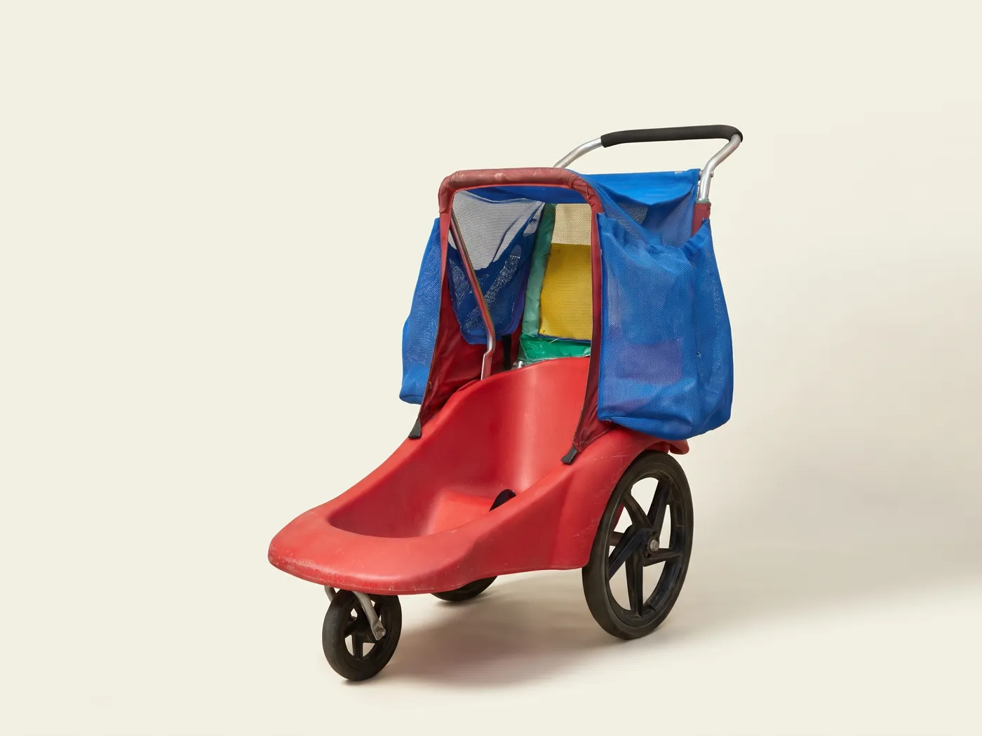 Double stroller with a red seat and blue canopy