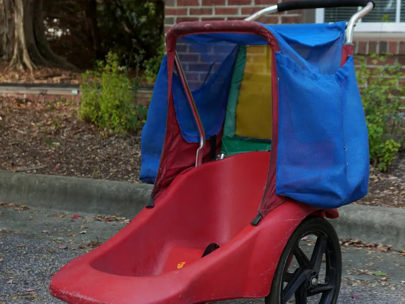 Red stroller with a blue canopy