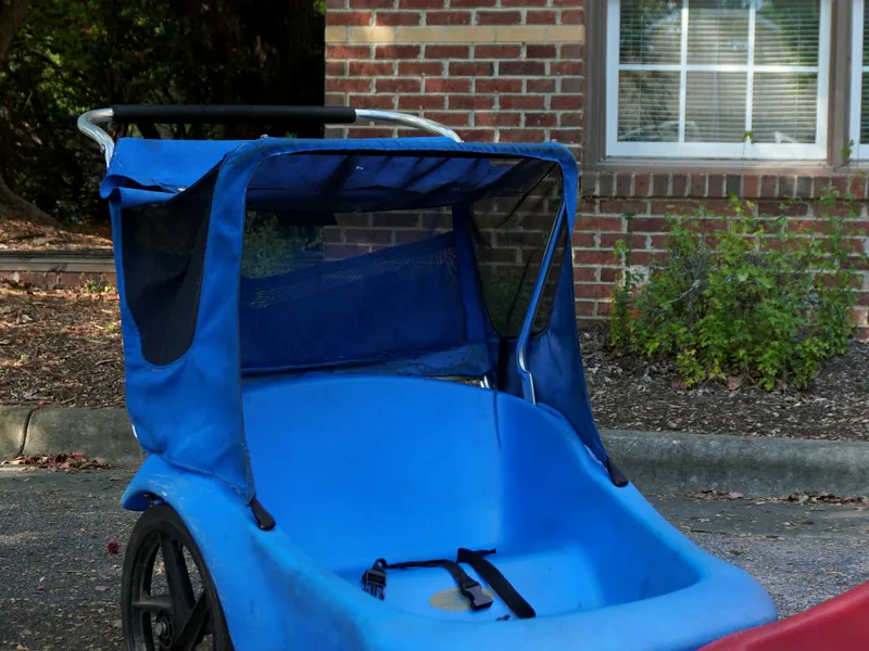 Blue stroller with a canopy and a seat belt